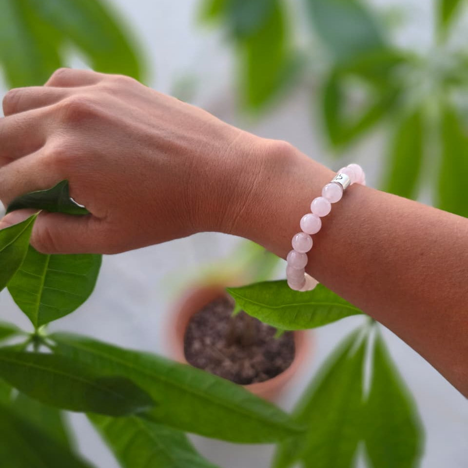 Pulsera de cuarzo rosa natural de 8 mm llevada en la muñeca, con piedras en delicados tonos rosados, diseño elegante y femenino