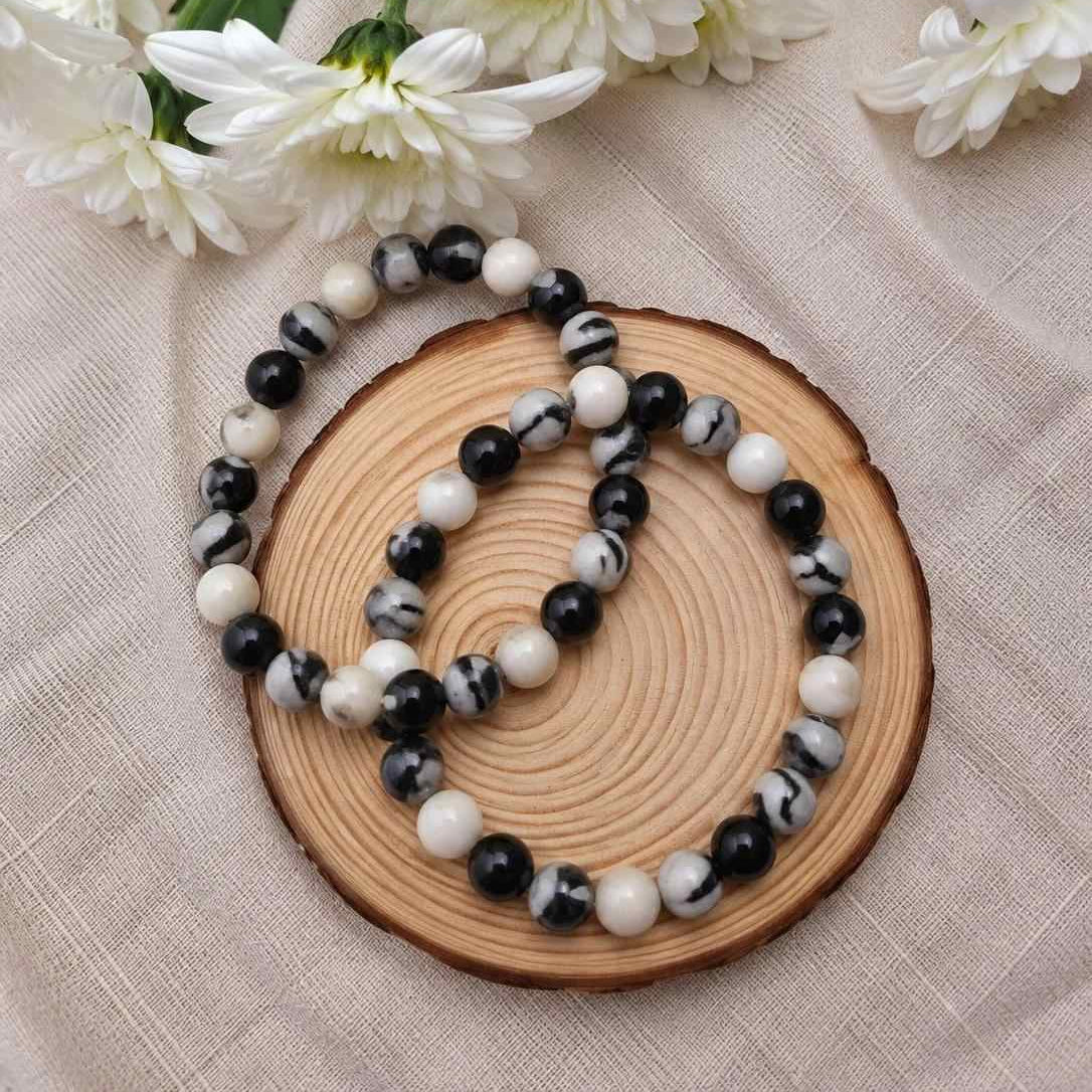 Pulsera de jaspe cebra natural de 6 mm con piedras en tonos blancos, grises y negros, con patrones únicos inspirados en las rayas de una cebra