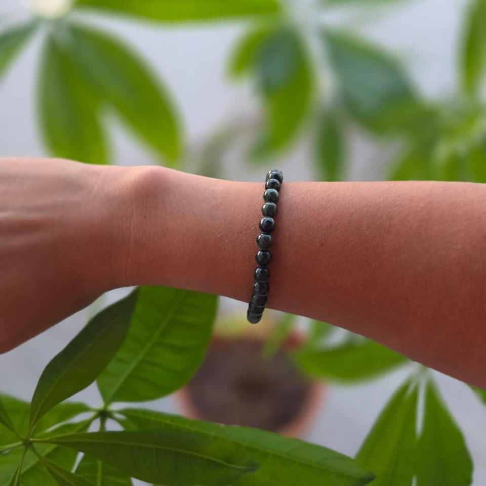 Pulsera de jaspe kambaba natural de 6 mm llevada en la muñeca, con piedras en tonos verdes y negros, patrones naturales y diseño elegante