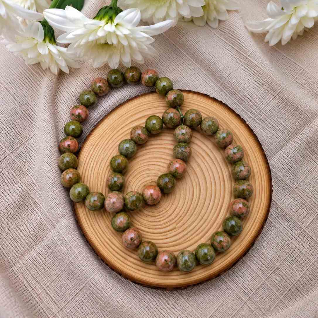 Pulsera de unakita natural de 6 mm con piedras en tonos verdes y rosados, con patrones naturales únicos y diseño elegante para uso diario