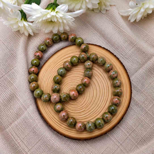 Pulsera de unakita natural de 6 mm con piedras en tonos verdes y rosados, con patrones naturales únicos y diseño elegante para uso diario